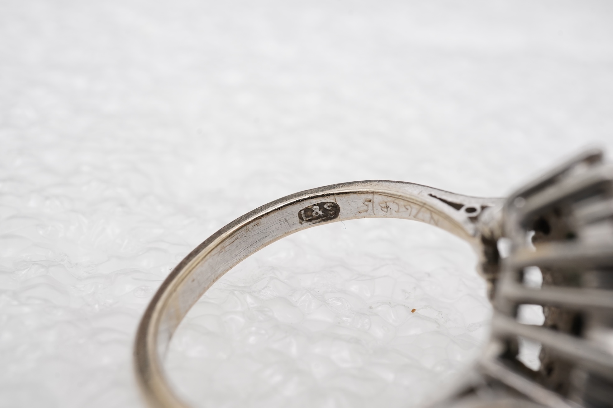 An emerald and diamond cluster ring